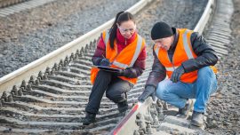 two crew members working on railroad track